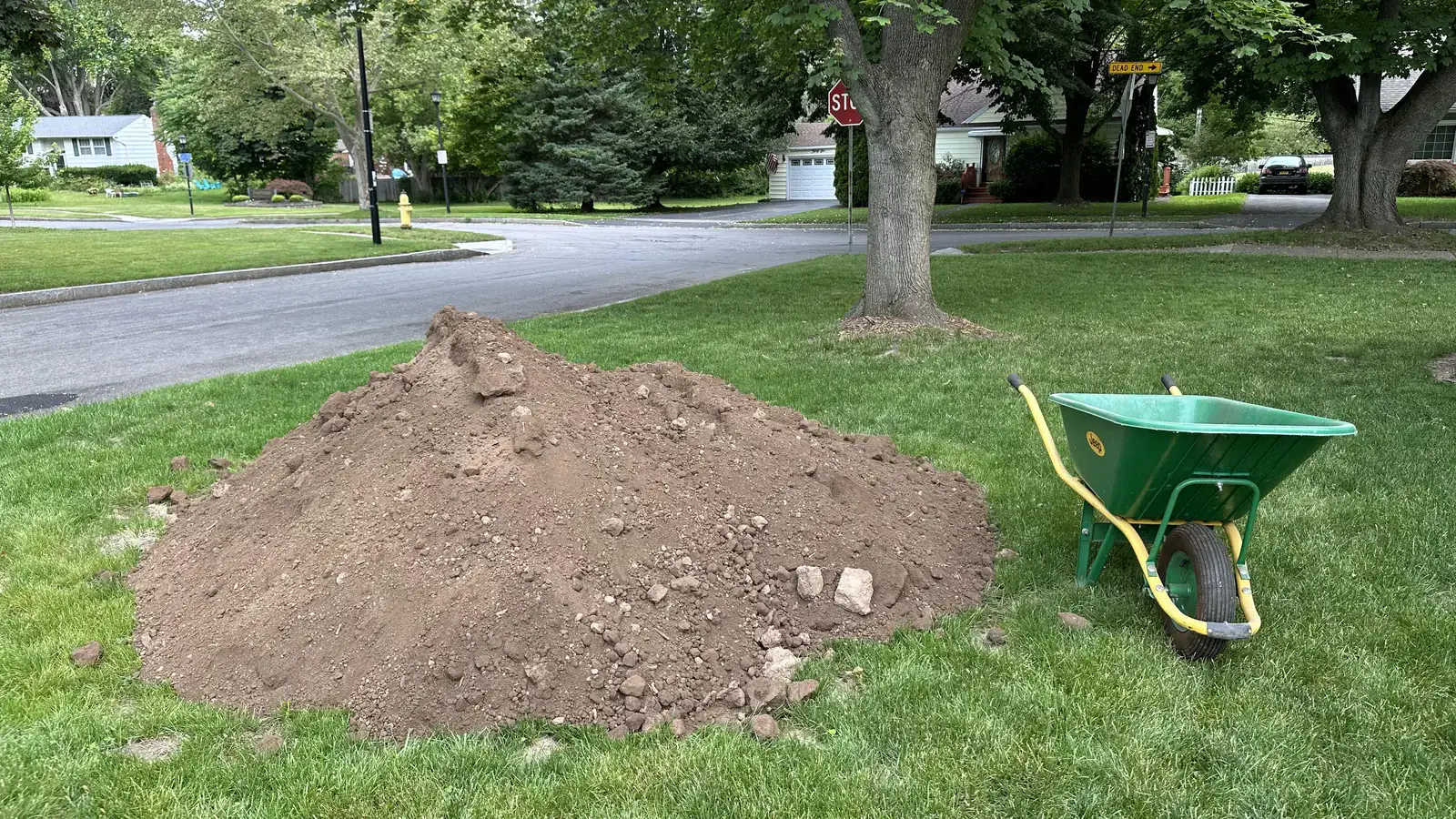 Pile of fill dirt dropped on a lawn ready to be spread into a low spot
