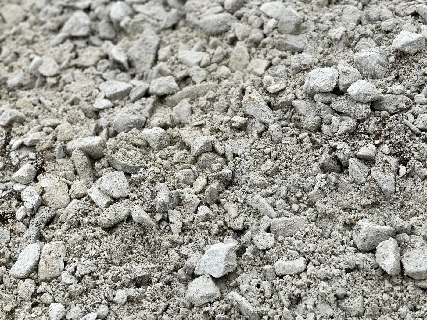Close-up of crushed stone and fines packed together on a gravel driveway surface